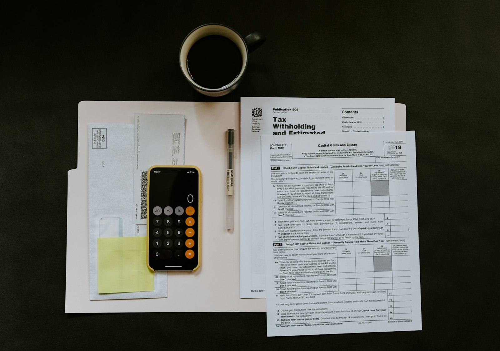 Calculadora, formatos fiscales y una taza de café sobre un escritorio